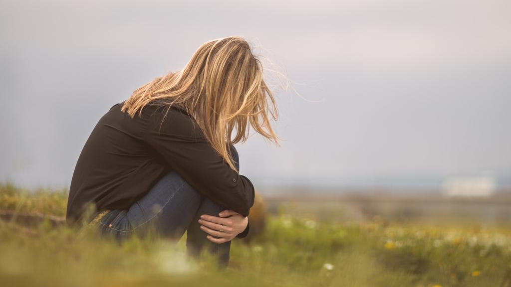 Woman sitting outside afraid